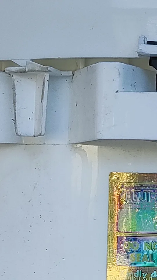 Close-up of the intact seal on the lid of a sealed Fuji-Chlon drum, beside the lock and hologram